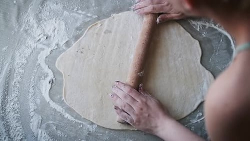 Woman Rolling Dough with Wooden Rolling Pin