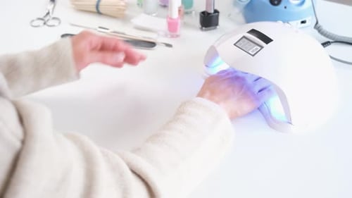 woman doing manicure at home, drilling the nails