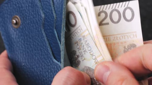 A Closeup View of Cash Being Stored in a Blue Wallet for Financial Purposes