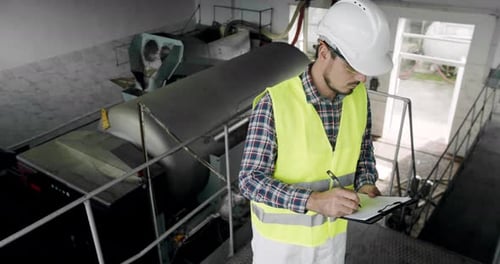 Un vigneron cherche du matériel pour la distillation et la fermentation dans une fabrique de vin
