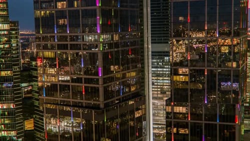 Lights reflecting off of buildings at night aerial