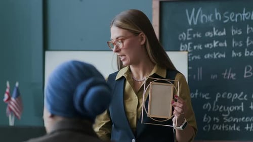 Teacher Holding Picture Frame and Flashcard in Classroom