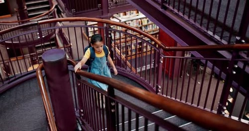 Girl, child and walking in library with books for research, education and knowledge for school