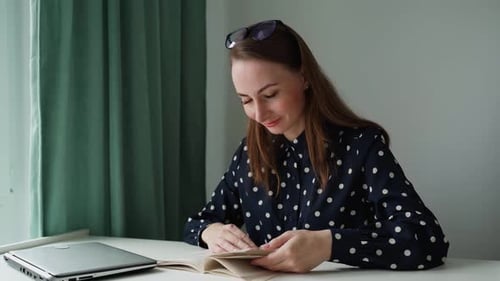Woman Reading Book at Desk Indoors