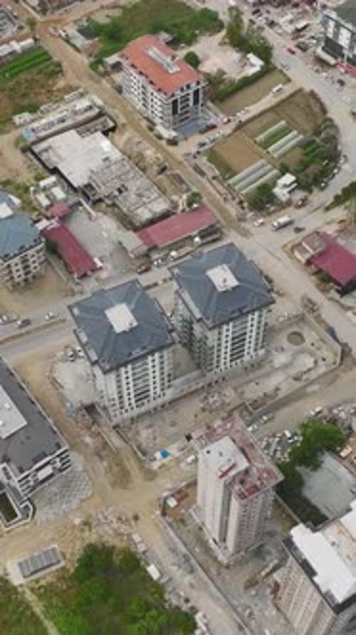 Los trabajadores de vídeo vertical construyen cimientos e instalan paneles de vidrio para balcones en una construcción grande