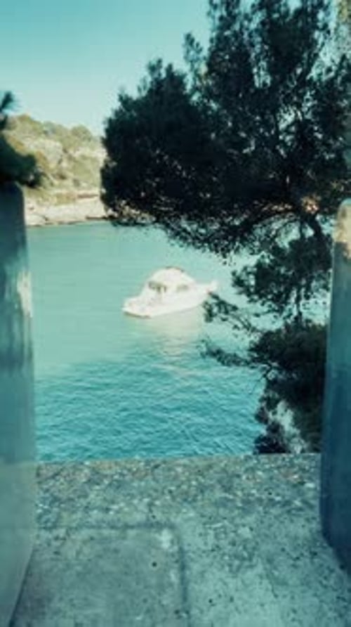 Beautiful vertical footage of boats cruising through Mallorca’s crystal-clear waters, with vibrant m