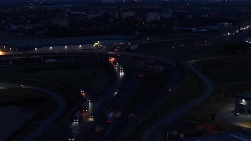 Aerial flyover multi level highway junction in Warsaw, Poland at night. Modern city with busy