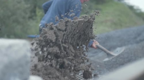 Man Shoveling Dirt and Gravel Outdoors