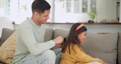 Dad Brushing Young Girl's Hair at Home