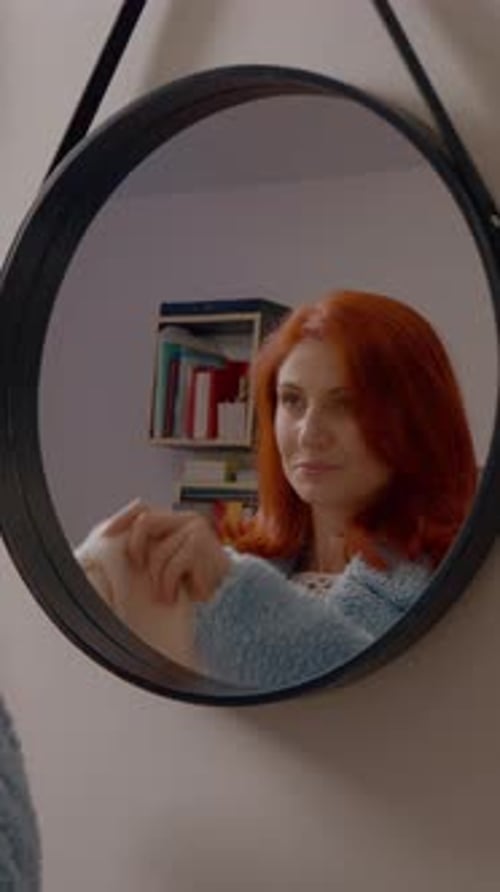 Vídeo vertical Mulher ruiva se prepara em sua casa, preparando-se para uma reunião matinal