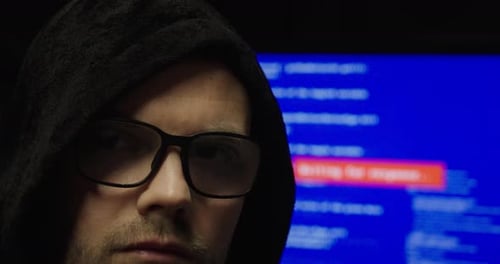 Anonymous Hacker in Hoodie with Code Screen