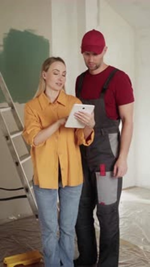Interior Designer Showing Tablet to Painter During Home Renovation