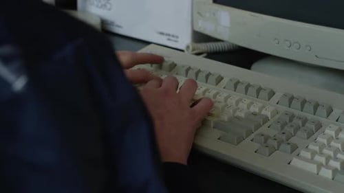 Person Typing on Vintage Computer Keyboard