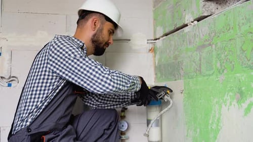 Construction Worker Repairing Plumbing Inside House