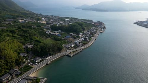 Slow motion drone tilt up over beautiful Seto Inland island scenery early in the morning