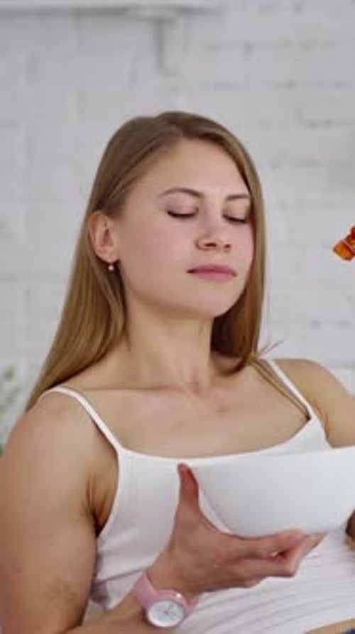 Young woman eating salad. Beautiful girl sniffing and eating organic vegetables