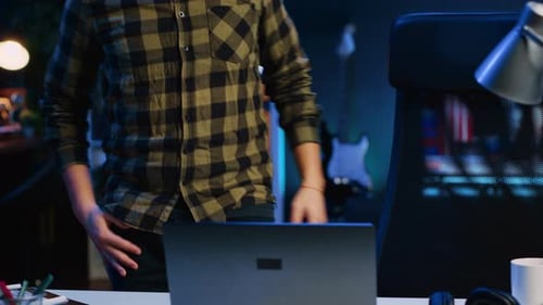 Man Sits Down and Uses Laptop at Night