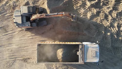 Excavator Fills Dump Truck with Dirt on Site
