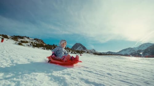 A Joyful Child Sledding Down a Snowy Hill in a Winter Wonderland on Vacation