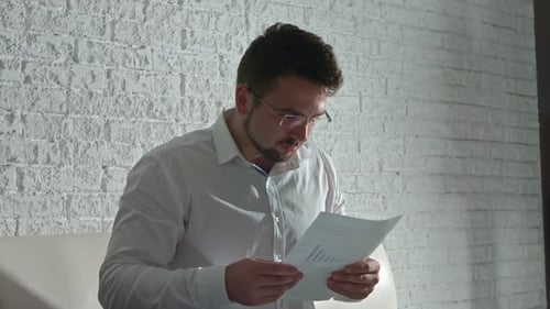 Problems in Young Businessman in the Office with Documents