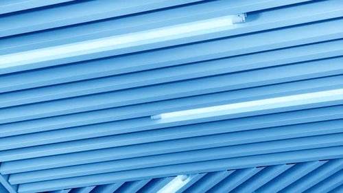 Switched on led lamps among the panels on the ceiling in diverse directions. View from below.