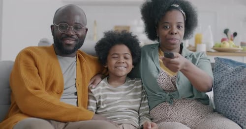 Happy Family Smiling on Sofa in Living Room
