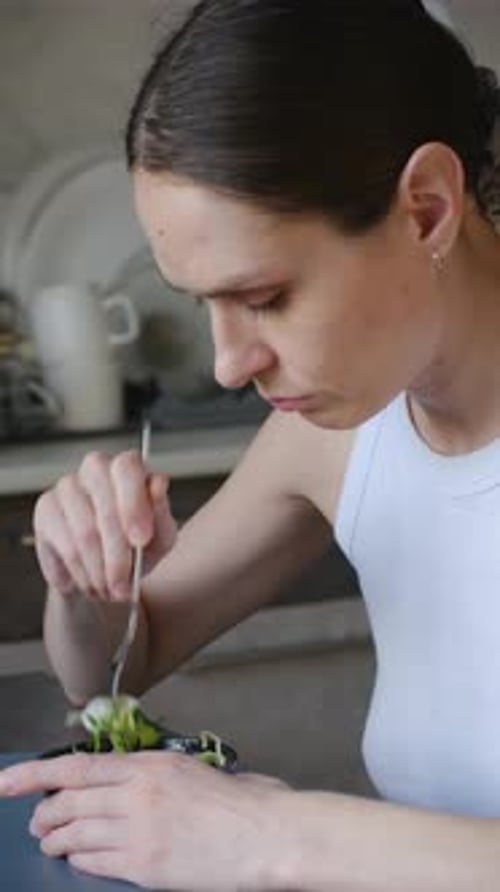 Unhappy Woman Eating a Green Salad on a Diet