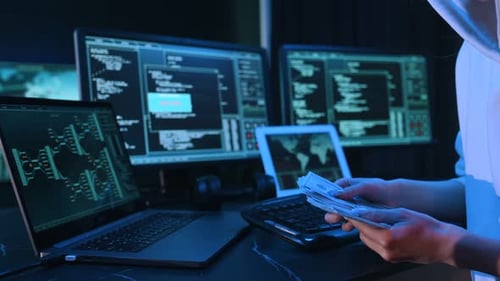 Woman Holding Cash at Computer Station with Multiple Screens