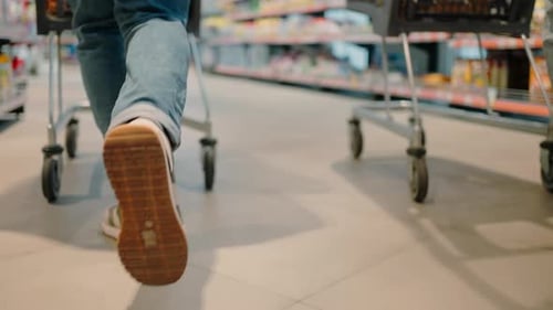 Shoppers Run Past Merchandise Shelves with Shopping Carts