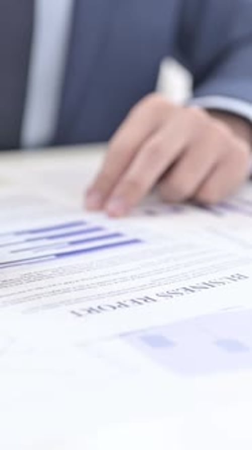 Man Reviewing Business Report with Charts and Data