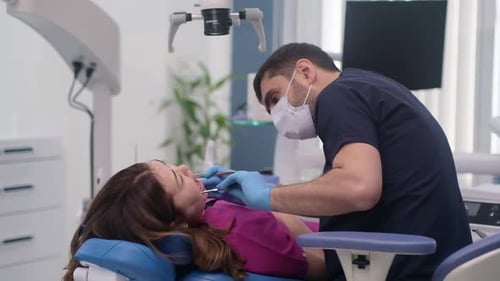 Professional Checkup of Patient in Dental Clinic Dentist in Protective Mask Checking Teeth of Woman