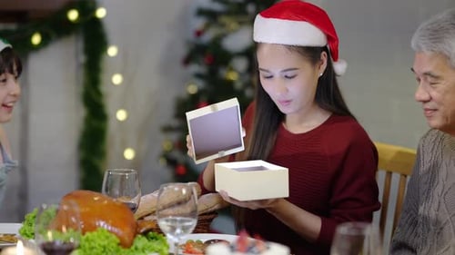 Family Celebrating Christmas and Opening Gifts at Dinner
