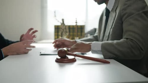 Two People Meeting with Gavel on Table
