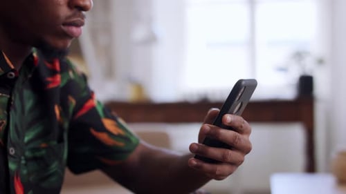 Man Using Smartphone Indoors During the Daytime