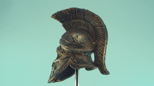 A rotating close up shot of a spartan ancient greek warrior metal bronze helmet, with shapes and for
