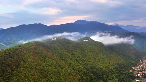 Brasov sign on the top of the hill near the city, green trees, Romania