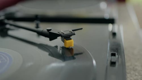 Close-up of a record player needle on a vinyl record, capturing the vintage audio equipment in use.