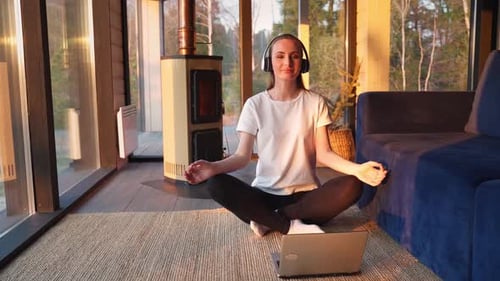 Woman Meditating at Home with Laptop and Headphones