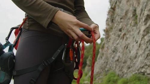 Female Mountain Climber Attaching Rope to Carabiner
