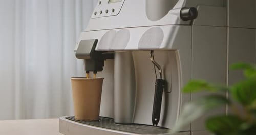 Coffee Machine Pouring Brewed Coffee into Paper Cup