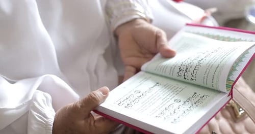 Muslim old woman who reads a holy Islamic book or quran in the month of Ramadan