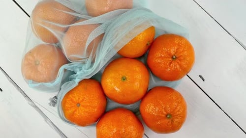 Ripe Juicy Tangerines in Ecofriendly Grid Rotate on White Background