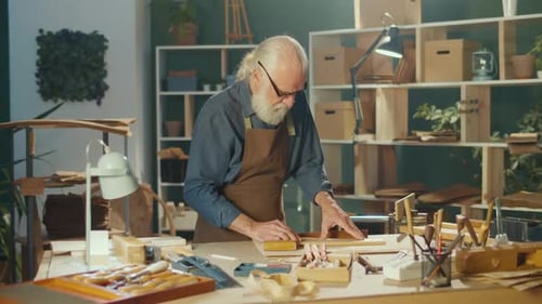 Senior Craftsman Works at Workbench in his Woodshop