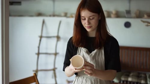 La Potter aux cheveux roux sort son œuvre du volant du potier et la vérifie