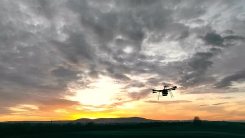 Drone Flying Over Rural Landscape at Sunset