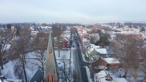 Lititz, Pennsylvania small town during winter snow. Rising aerial features steeple at Linden Hall, M