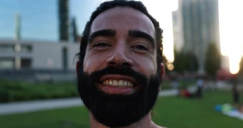 Smiling man with beard in urban park environment