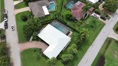 Aerial top down of luxury villas with swimming pool during sunny day in Florida, USA. Car driving on