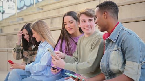 Happy Friends Enjoying Cell Phone Together Outdoors