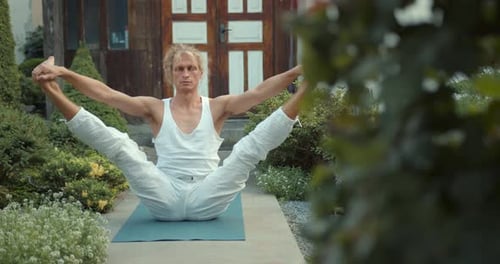 Man Doing Yoga Outside in Peaceful Garden Setting